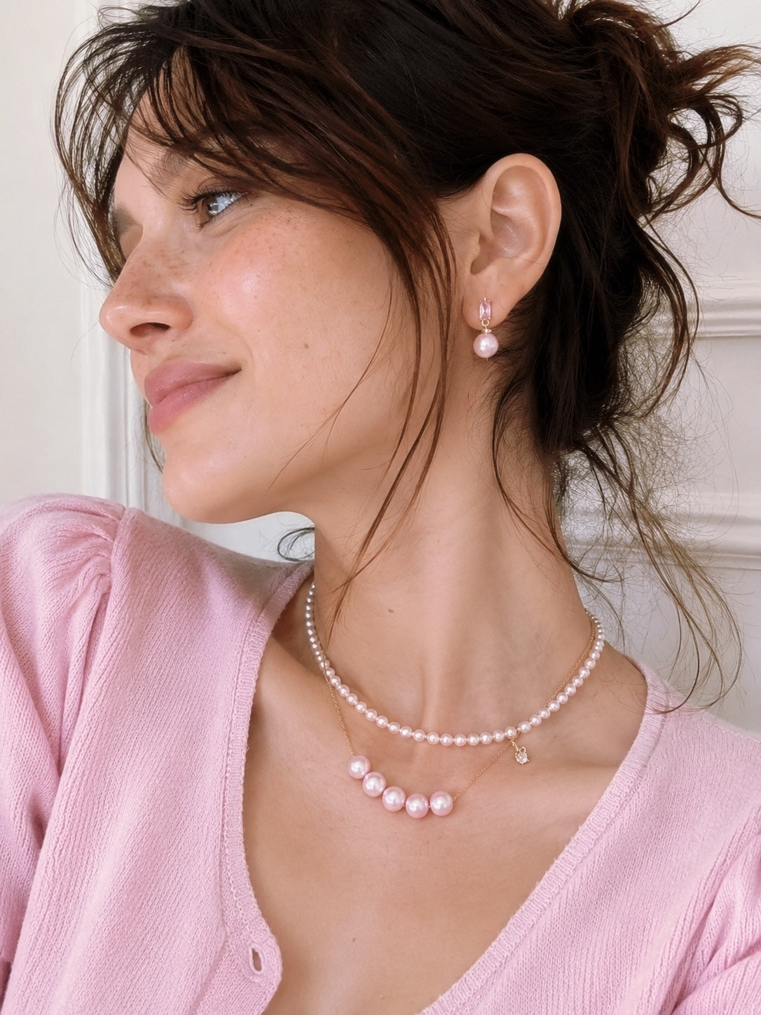 Pink pearl necklace and earrings worn with a blush dress