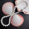 Étreinte de Perle Pearl Necklace styled on pink shells