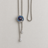 Midnight Orbit purple pearl brooch styled with a long chain