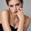 Model wearing Midnight Orbit pearl earrings, ring and brooch styled as a pendant