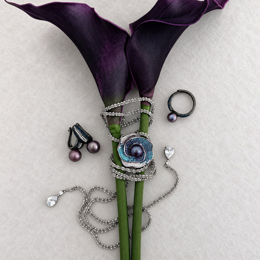 Midnight Orbit pearl jewellery styled with purple calla lilies