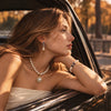 Model wearing the Aurelia Halo pearl pendant with Iris pearl necklace and an ivory strapless top