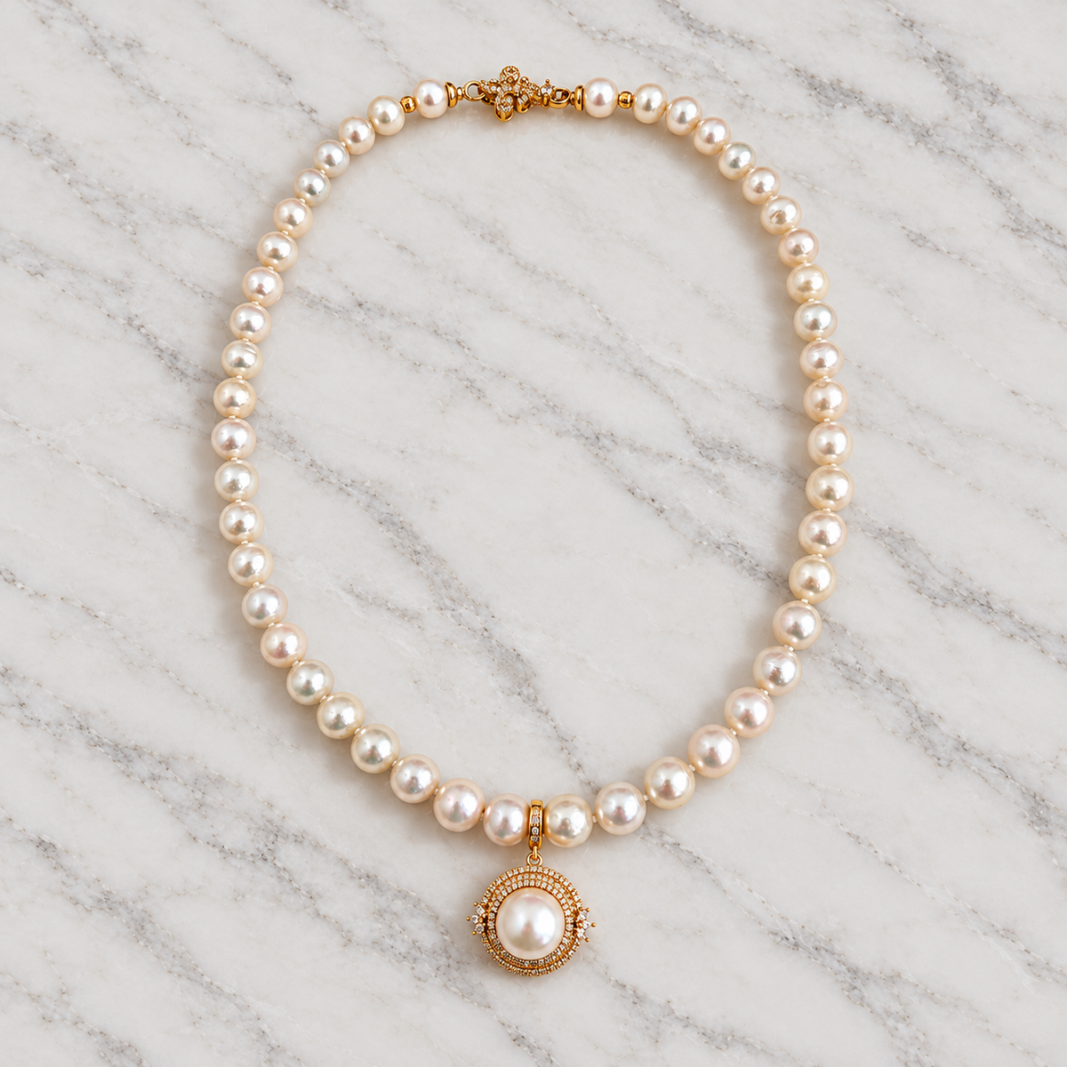 Aurelia Halo pendant and Iris pearl necklace on pale marble, square styling photo