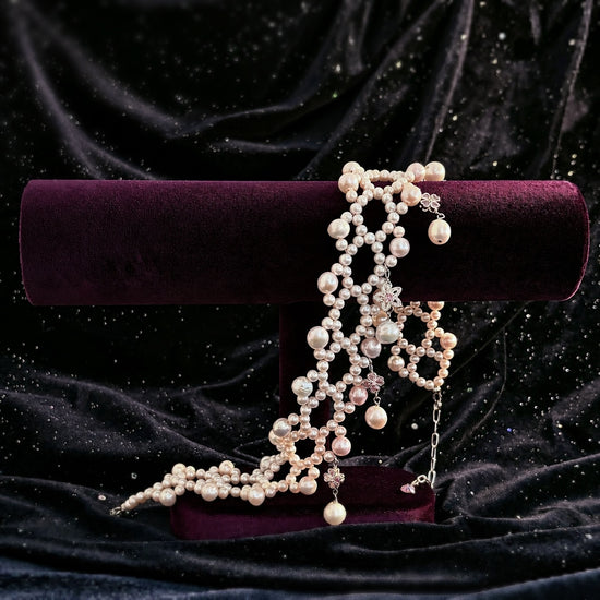 Ballet Rosé woven pink pearl bracelet displayed with its matching necklace on a purple velvet stand