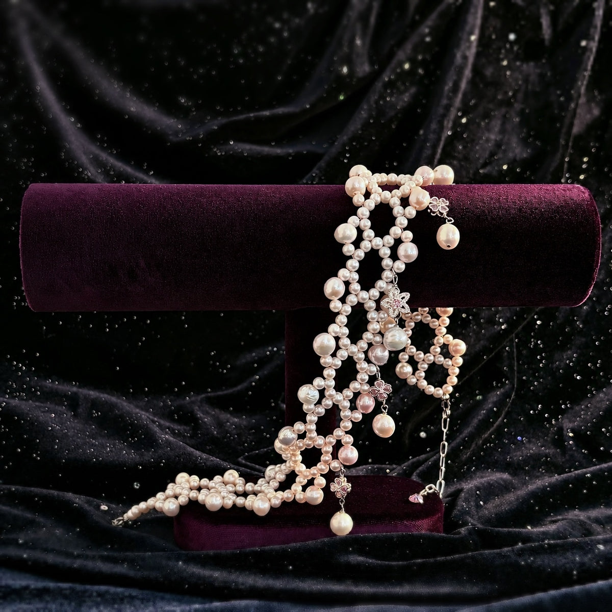 Ballet Rosé woven pink pearl bracelet displayed with its matching necklace on a purple velvet stand