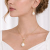 Model wearing NINEMOO Fleur de Lumière gold-tone pearl pendant necklace and matching earrings