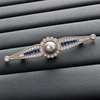 Grey pearl and blue stone brooch front detail on dark tray