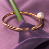 Lueur Rosée Éclat gold pearl bangle on purple fabric