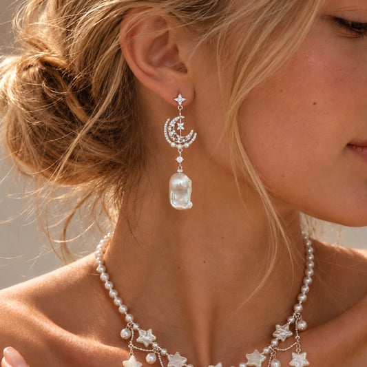 Moonlit Bloom Baroque Pearl Earrings in silver by NINEMOO worn on the ear, with crescent moon, stars and a white baroque pearl.