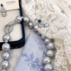 Nacre Gris grey freshwater pearl necklace with circular clasp beside lace and pearl jewellery