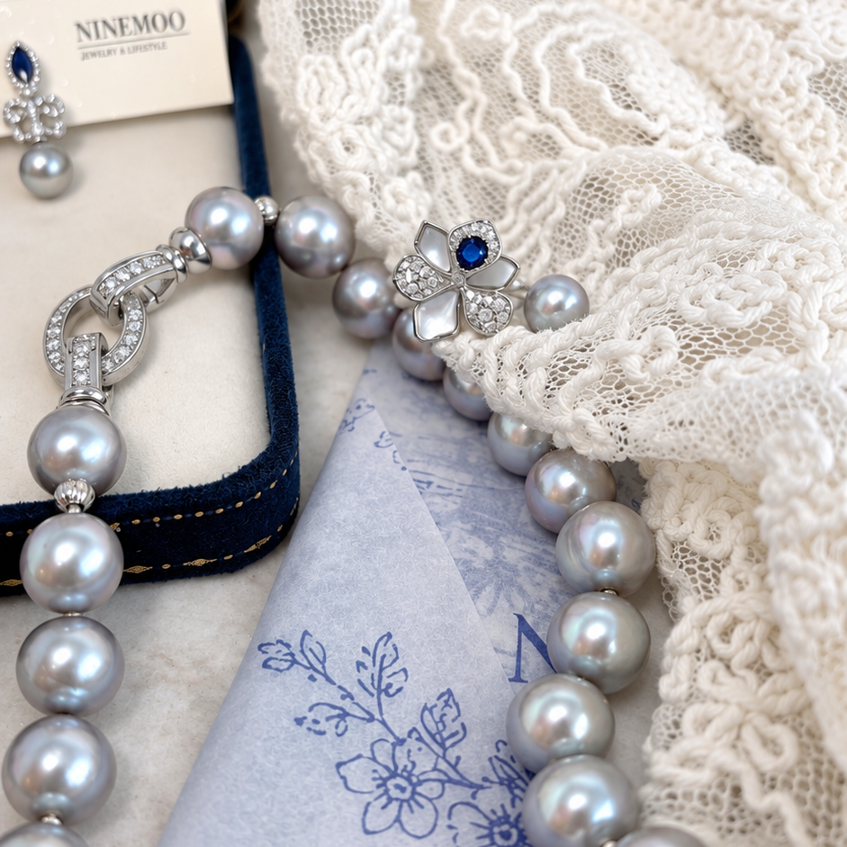 Nacre Gris grey freshwater pearl necklace with circular clasp beside lace and pearl jewellery