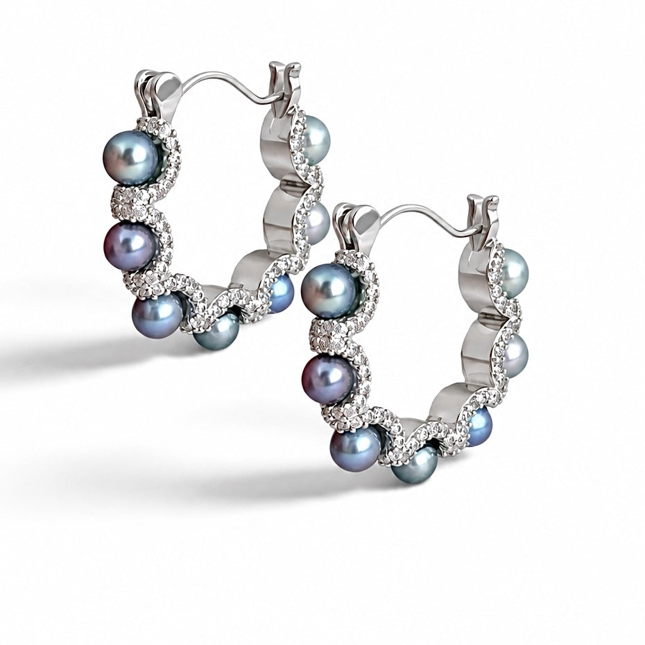 Pair of Nacre Noire hoop earrings with 4mm peacock green saltwater pearls and thick platinum plating on a white background
