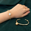 NINEMOO Solara Golden Pearl Wave Cuff and Lueur Rosée Éclat gold pearl bangle styled together on the wrist.