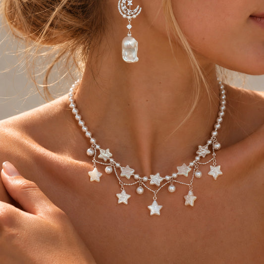 Stardust Waltz Necklace in white by NINEMOO worn at the neckline, showing freshwater pearls and mother-of-pearl stars.